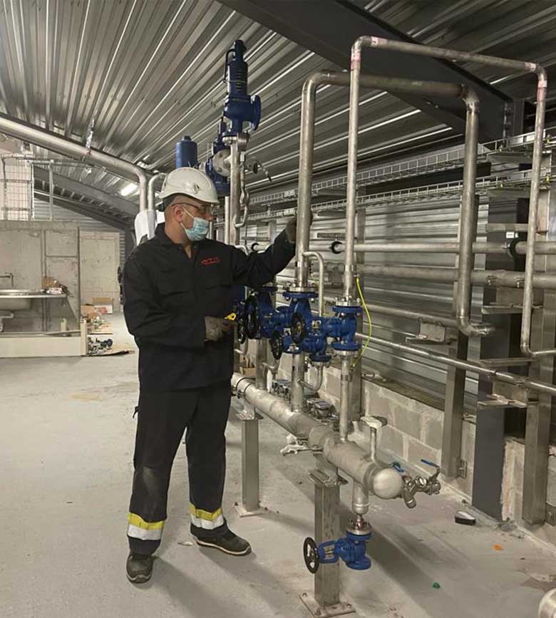 werknemer die industriële leidingen onderhoudt
