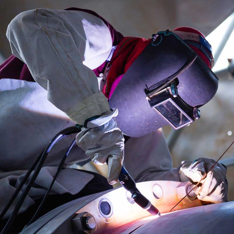 technicien qui travaille sur des tuyaux industriels